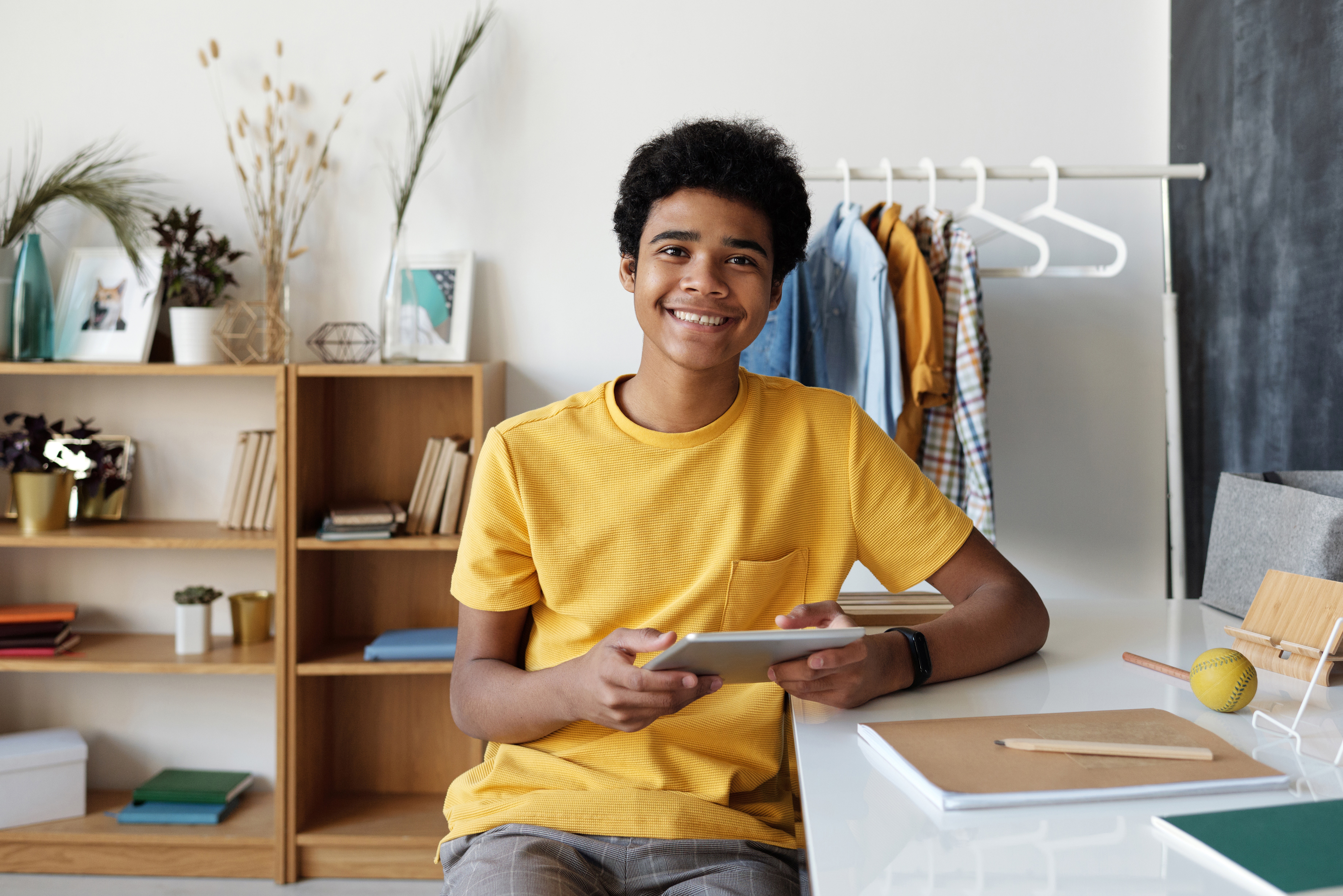 Un joven sonriendo con una tablet en las manos