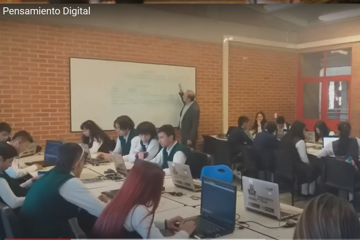 Profesor Luis Alberto Gómez dictando clase a unos 15 estudiantes