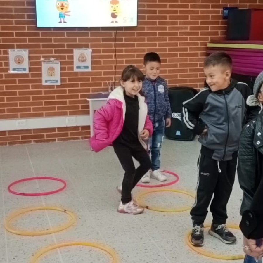 Niños saltando a través de aros que están en le suelo