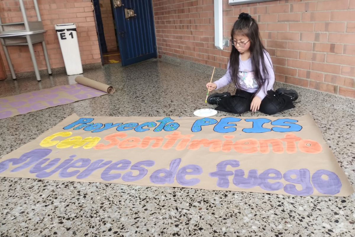 Niños en un salón mostrando cada uno un marco en madera