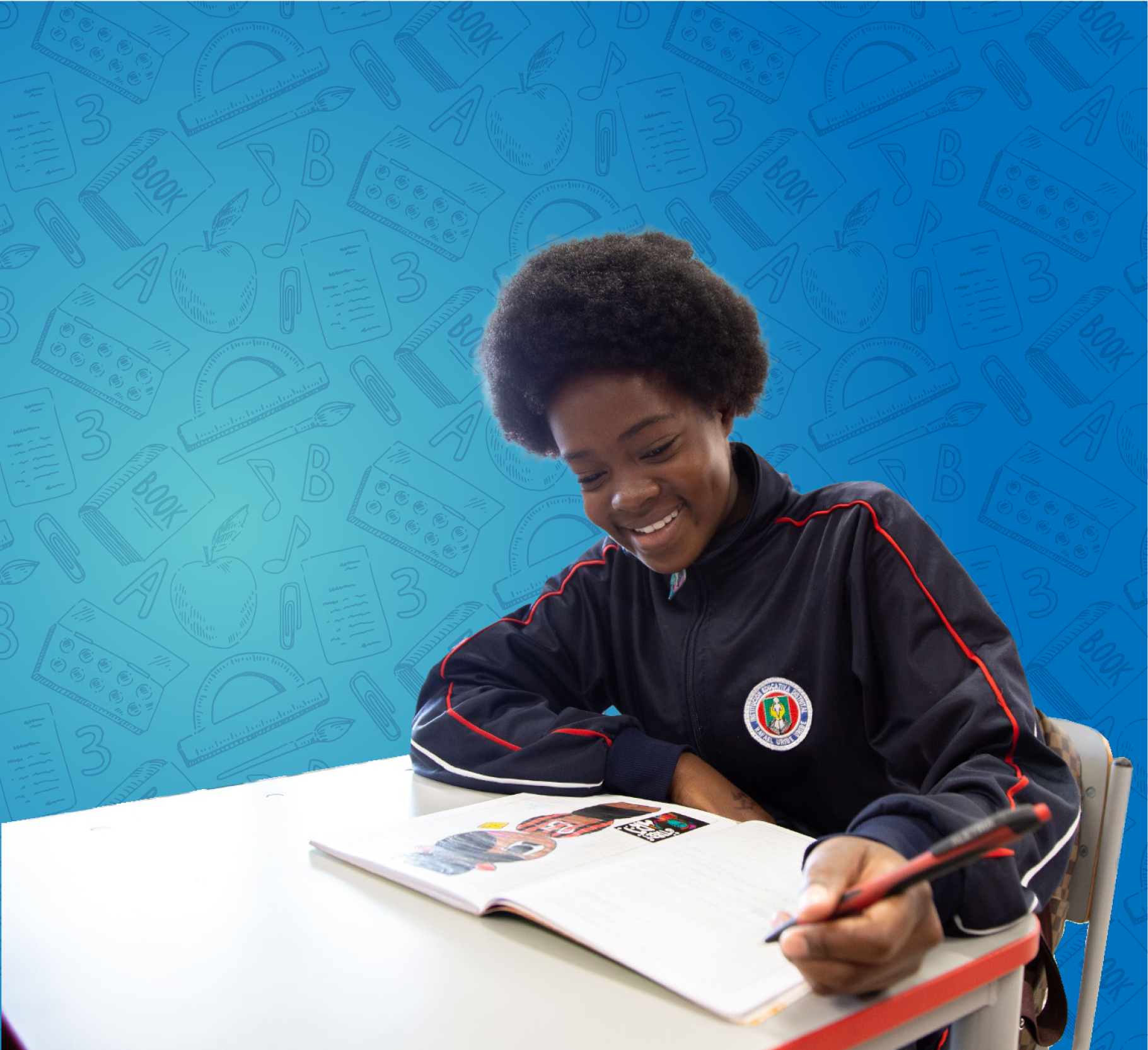 Foto de un niño sonriendo, escribiendo en un cuaderno