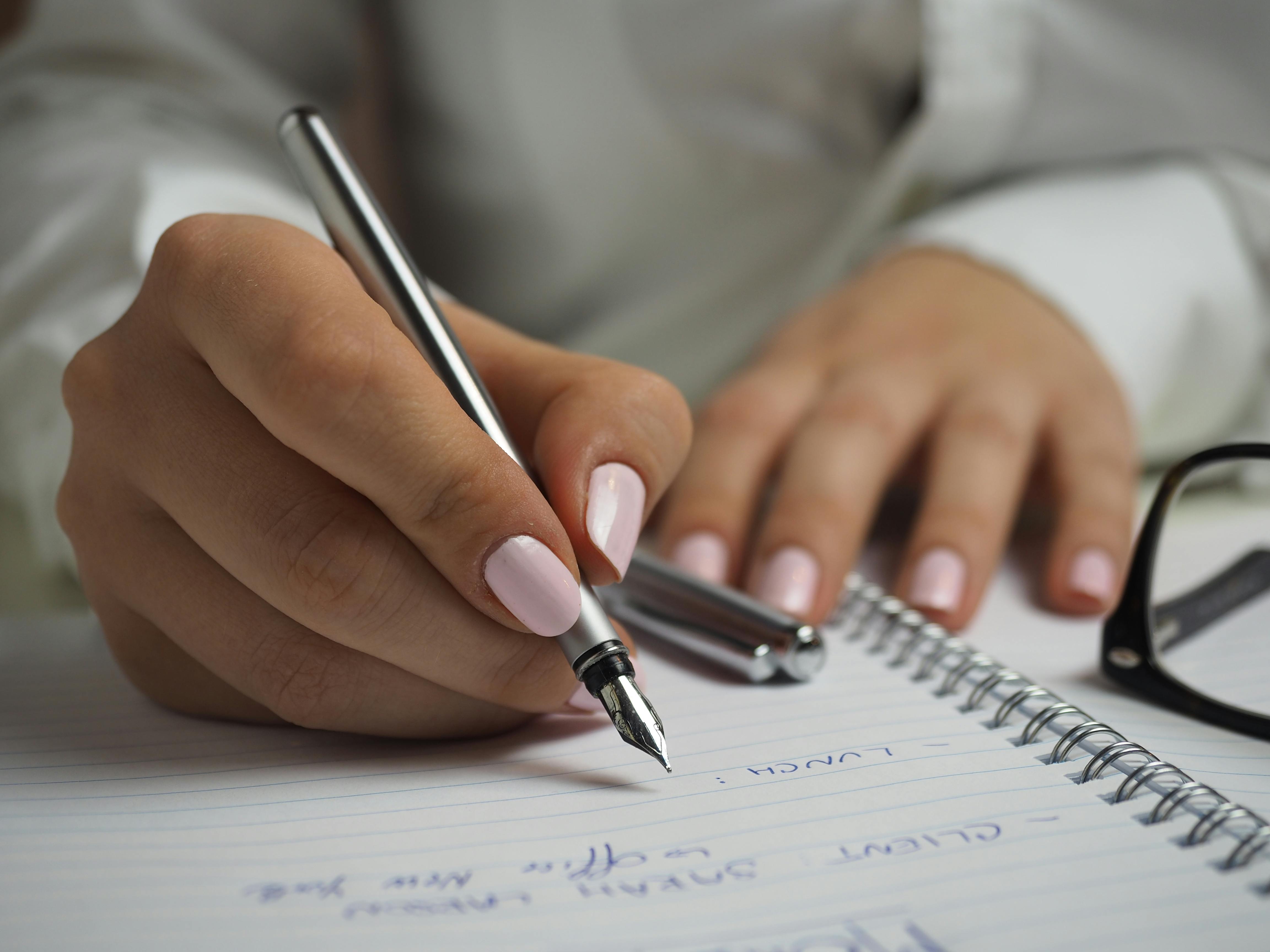 Foto de unas manos escribiendo en una hoja