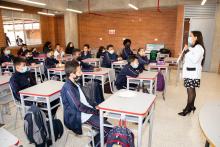 Profesora dictando clase a varios estudiantes 